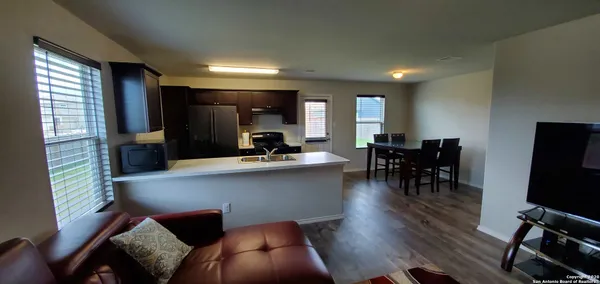 a living room with furniture a flat screen tv and kitchen view