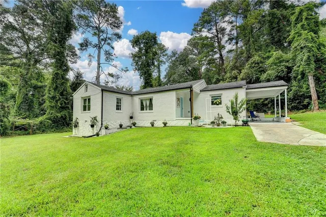 a view of a house with backyard and a tree