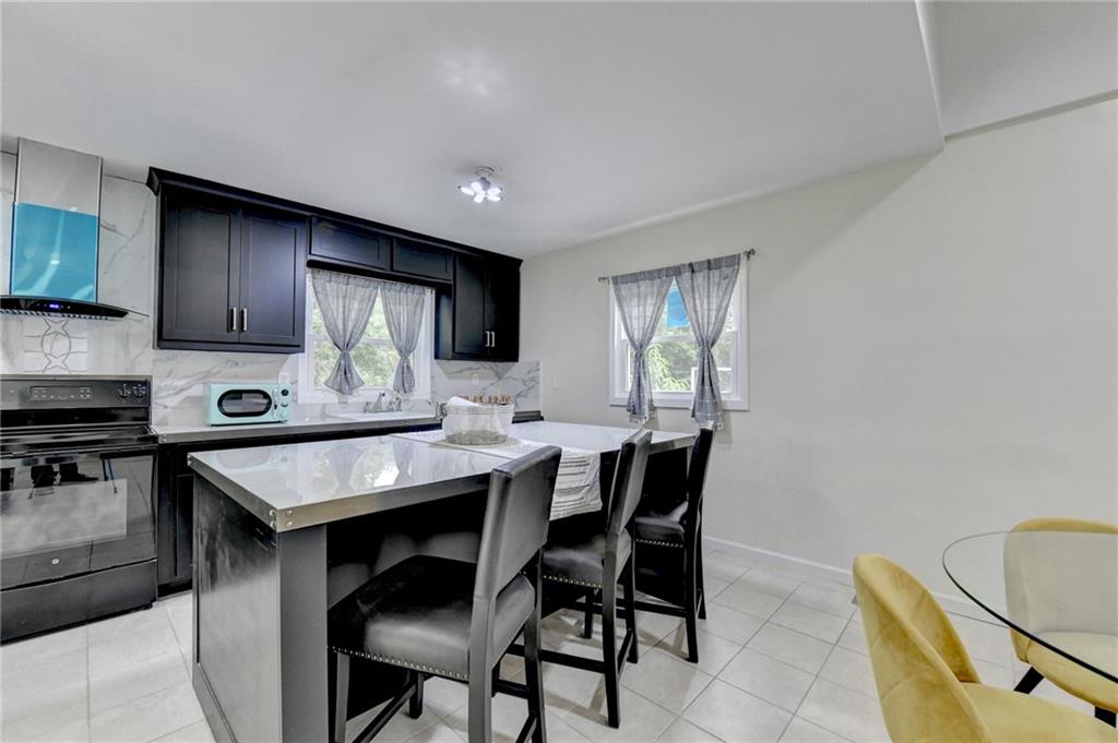 6654 Covington Road Lithonia, GA 30058 - Photo 11 of 39 a kitchen with a table chairs sink and cabinets