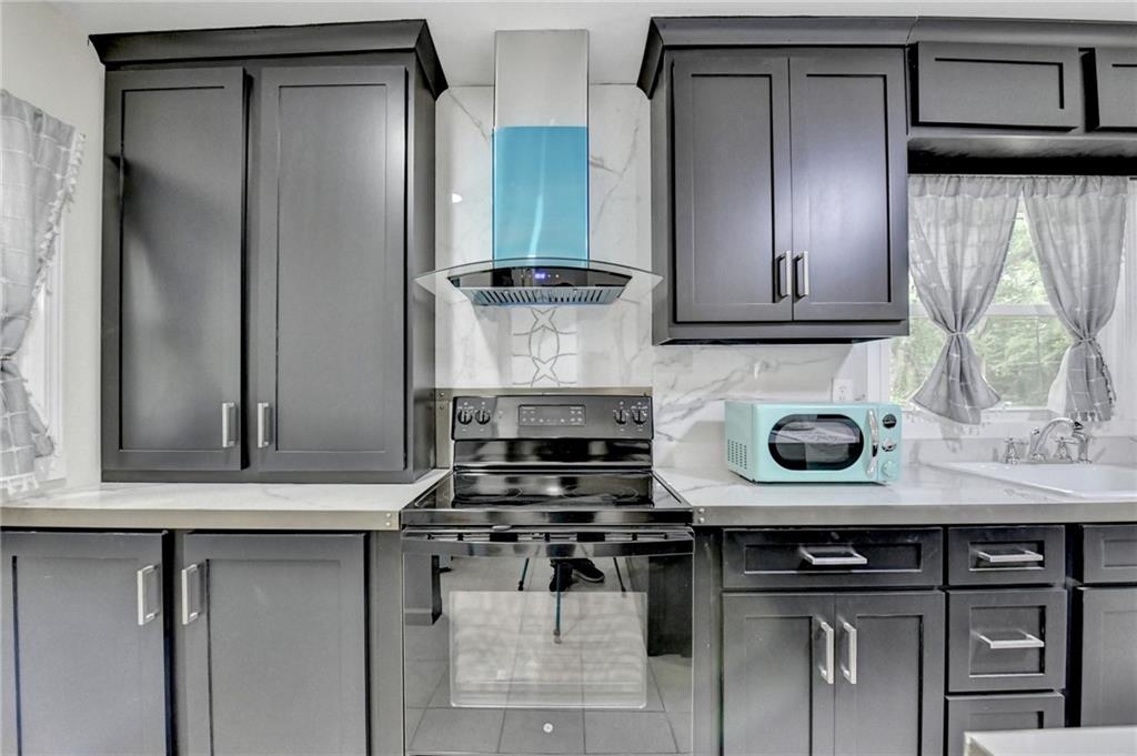 6654 Covington Road Lithonia, GA 30058 - Photo 13 of 39 a kitchen with stainless steel appliances granite countertop a stove and a cabinets