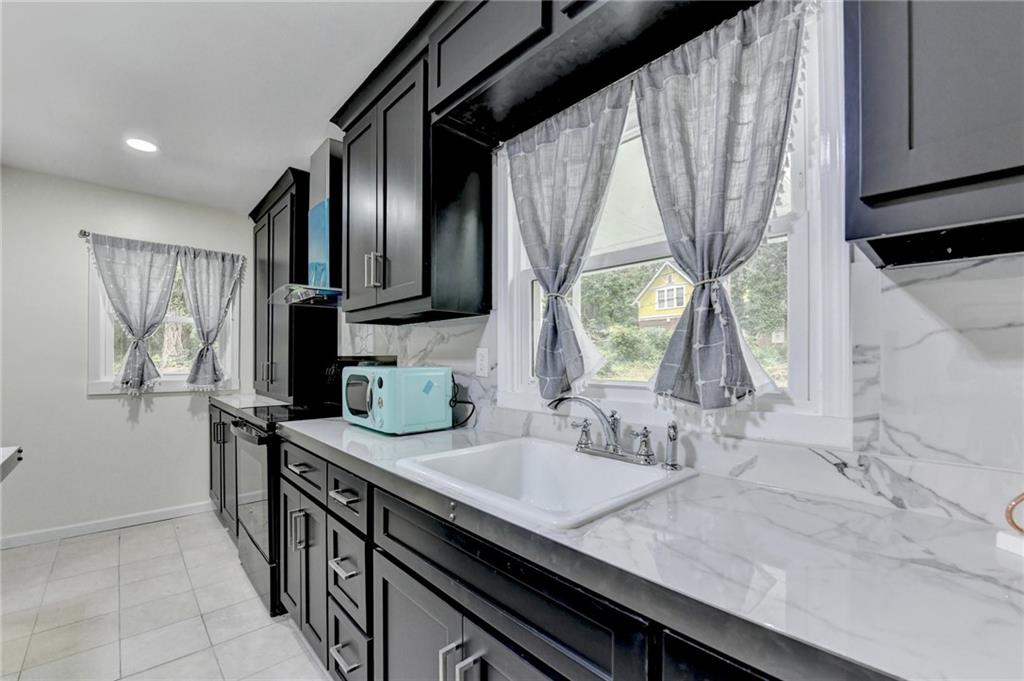 6654 Covington Road Lithonia, GA 30058 - Photo 15 of 39 a kitchen with sink a window and cabinets