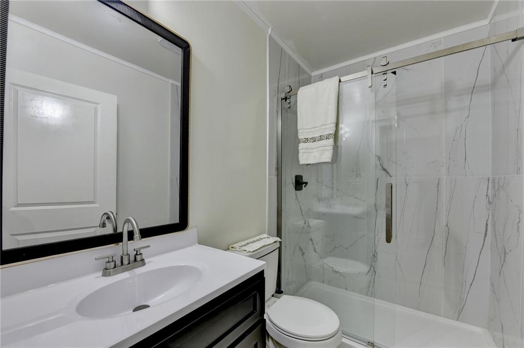6654 Covington Road Lithonia, GA 30058 - Photo 22 of 39 a bathroom with a sink toilet a mirror and shower