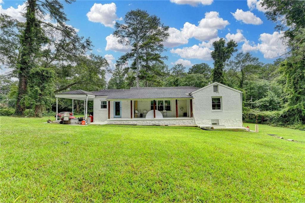 6654 Covington Road Lithonia, GA 30058 - Photo 29 of 39 a front view of a house with a garden and trees