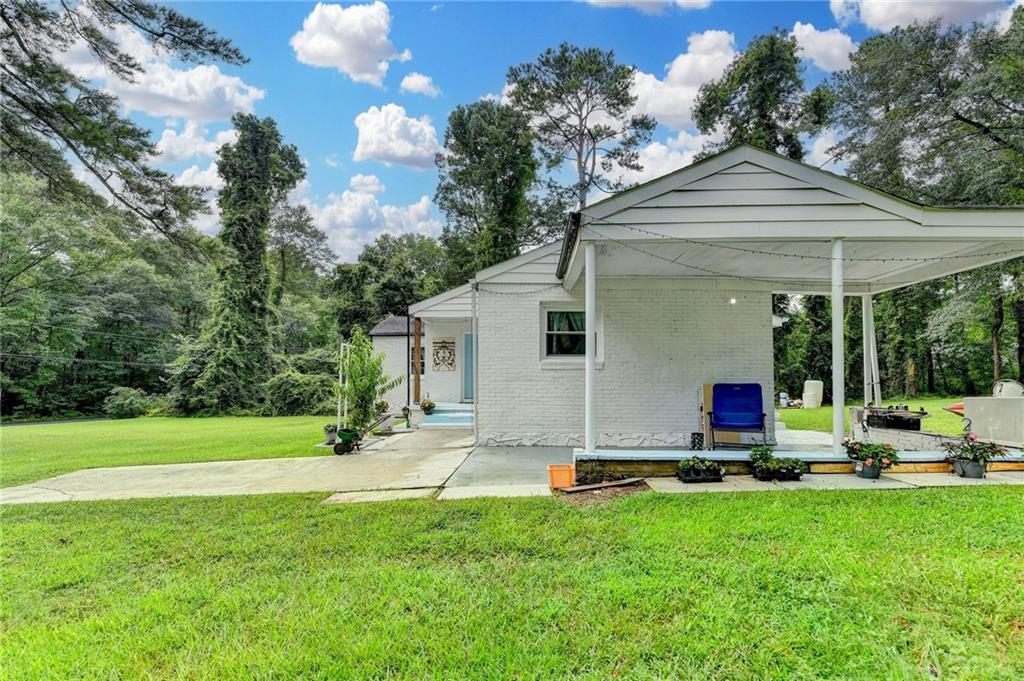 6654 Covington Road Lithonia, GA 30058 - Photo 30 of 39 a view of a house with a backyard and sitting area