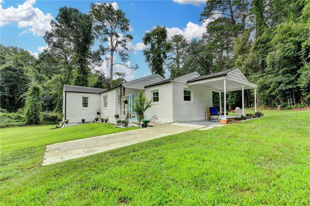 6654 Covington Road Lithonia, GA 30058 - Photo 3 of 39 a front view of a house with a yard and trees