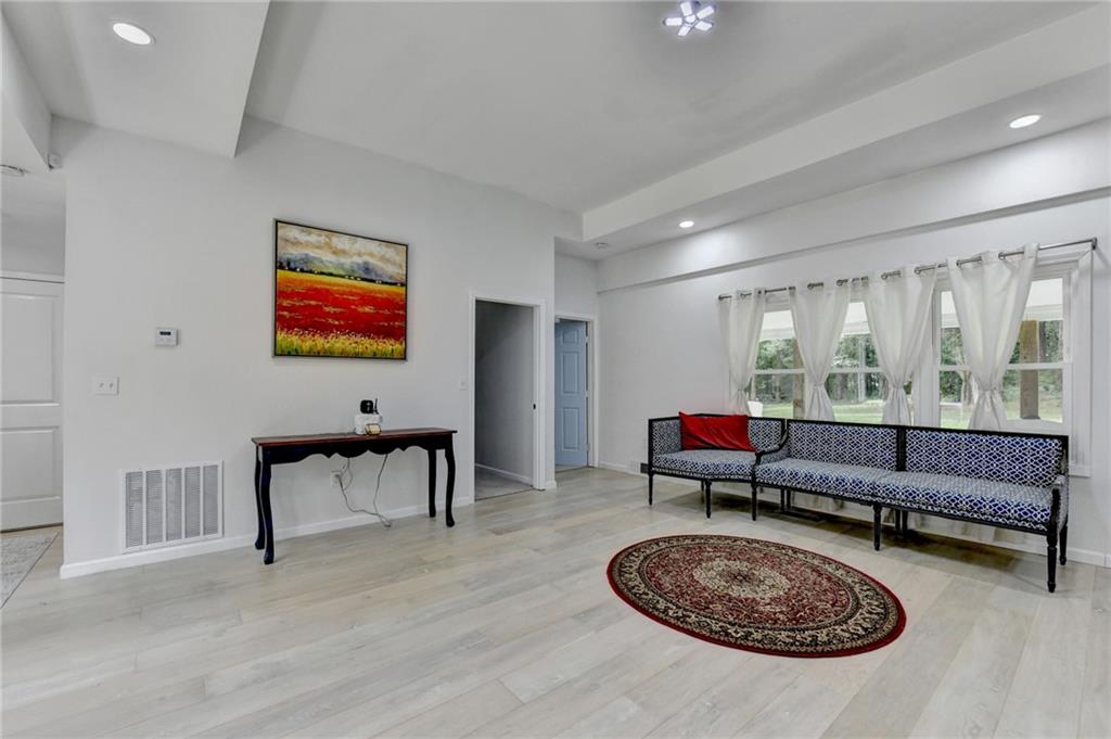 6654 Covington Road Lithonia, GA 30058 - Photo 7 of 39 a living room with furniture a rug and a floor to ceiling window