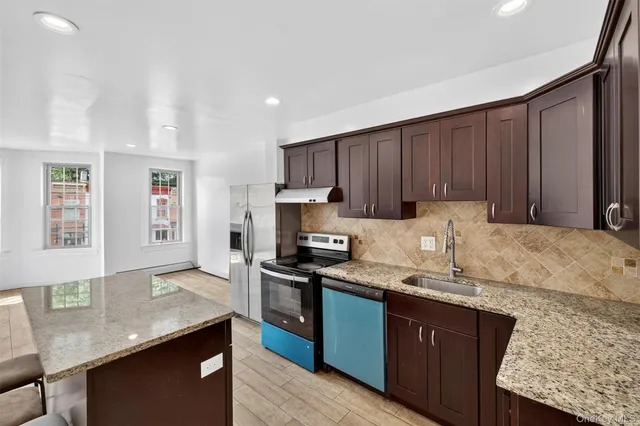 a kitchen with granite countertop stainless steel appliances and wooden cabinets