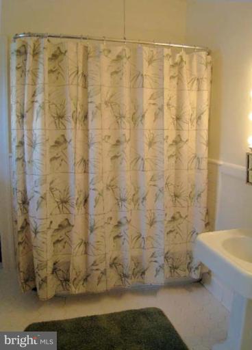 3926 Cloverhill Road Baltimore, MD 21218 - Photo 18 of 24 a bathroom with a shower curtain