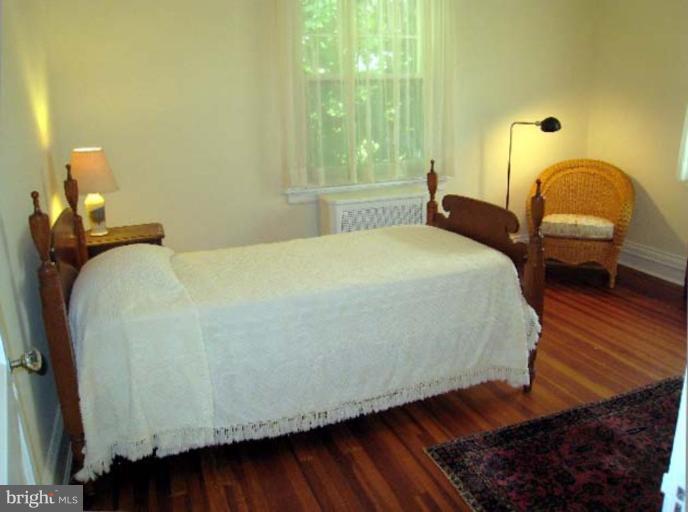 3926 Cloverhill Road Baltimore, MD 21218 - Photo 7 of 24 a bedroom with a bed and a chair