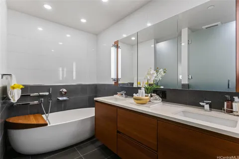 a bathroom with a bathtub sink and mirror