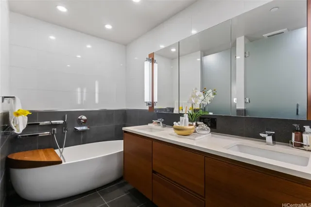a bathroom with a bathtub sink and mirror