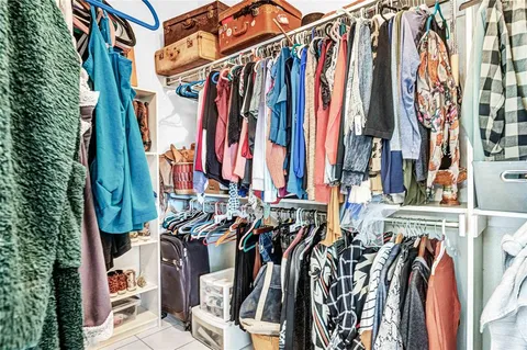 a view of walk in closet with clothes