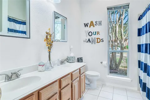 a spacious bathroom with a sink a toilet and a large mirror