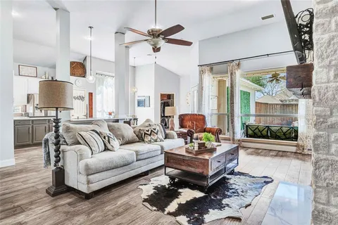 a living room with furniture wooden floor and a large window