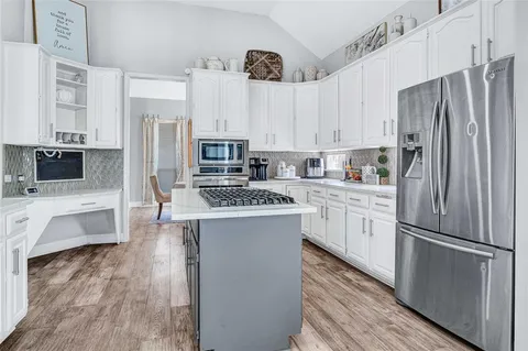 a kitchen with stainless steel appliances a refrigerator sink and cabinets