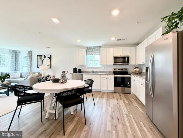 a kitchen with stainless steel appliances kitchen island granite countertop a sink dishwasher a stove a refrigerator with island and chairs