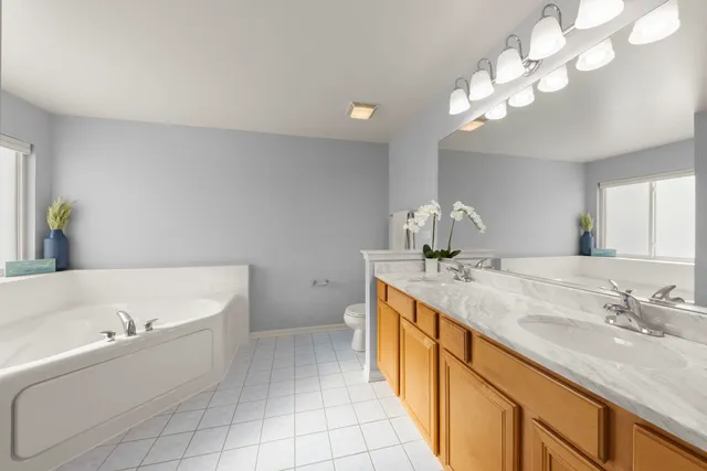 a bathroom with a tub a sink and mirror