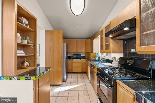 a kitchen with stainless steel appliances granite countertop a stove and a refrigerator