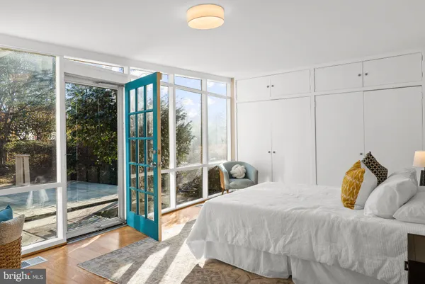 a bedroom with a bed and glass door