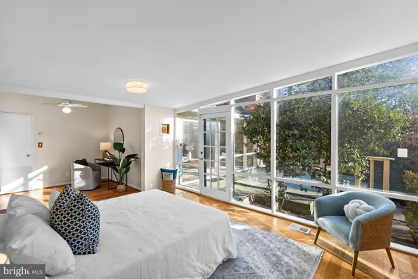 a bedroom with furniture and large windows