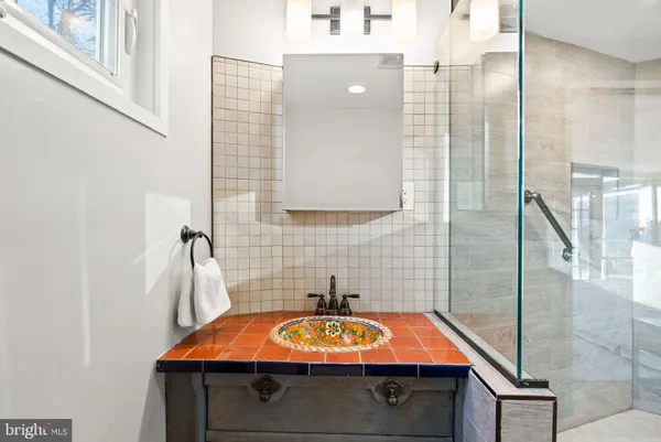 a bath room with a sink and mirror