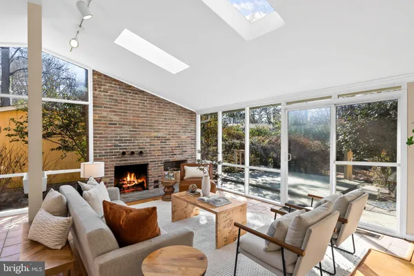 a living room with furniture fireplace and a large window