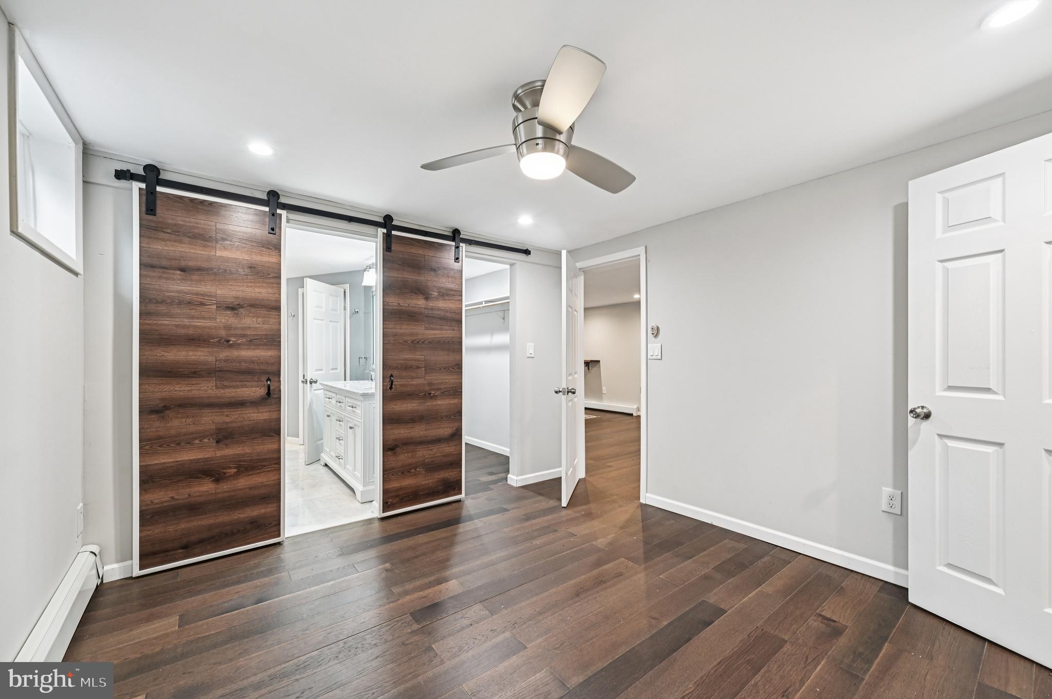536 Maple Ridge Lane Odenton, MD 21113 - Photo 38 of 48 a view of an empty room with a ceiling fan wooden floor and window