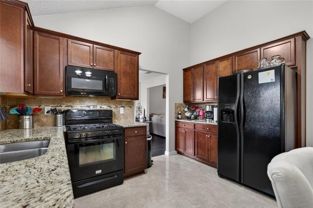 45 Windscape Drive Covington, GA 30016 - Photo 13 of 39 a kitchen with a refrigerator stove and sink