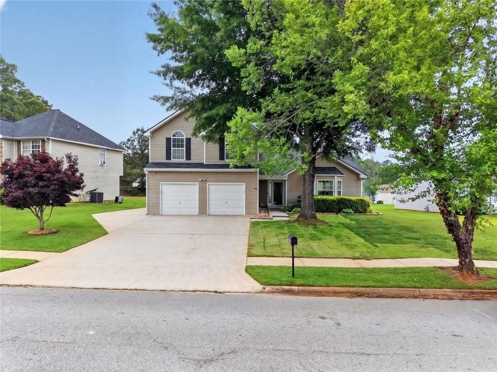 45 Windscape Drive Covington, GA 30016 - Photo 2 of 39 a front view of a house with a yard and large tree