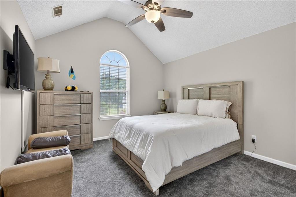 45 Windscape Drive Covington, GA 30016 - Photo 26 of 39 a bedroom with a bed a couch and a chandelier