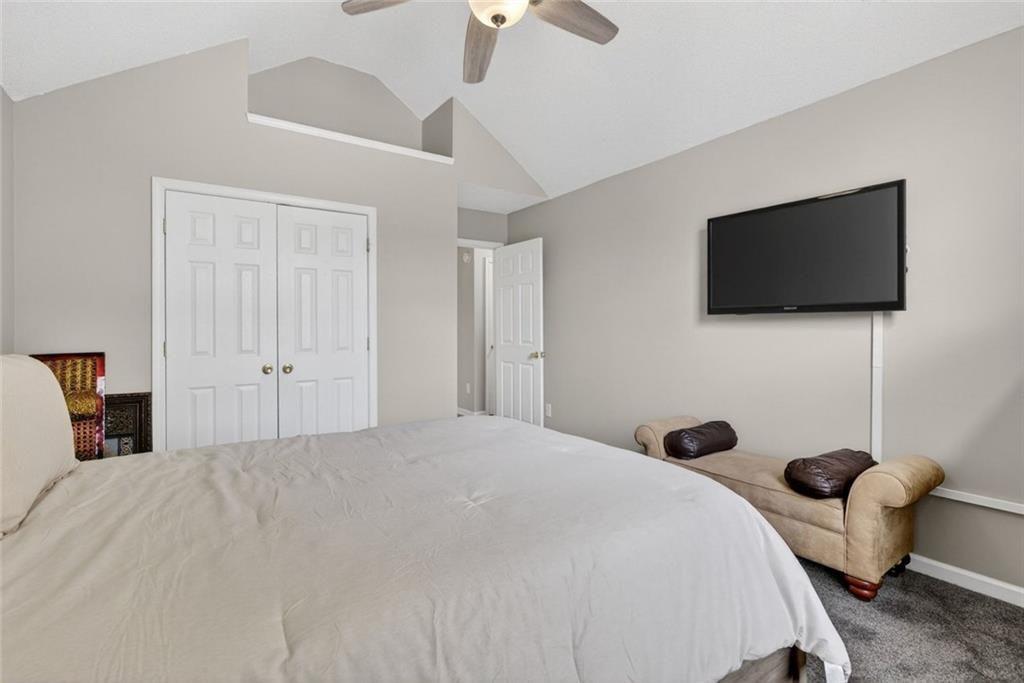 45 Windscape Drive Covington, GA 30016 - Photo 27 of 39 a bedroom with a bed a flat screen tv and a chandelier