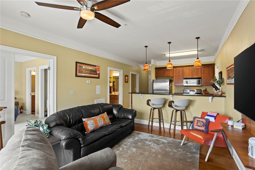 101 Oak Street, Unit 401 Clemson, SC 29631 - Photo 11 of 26 This inviting space combines living and kitchen areas, featuring hardwood floors and elegant crown molding.