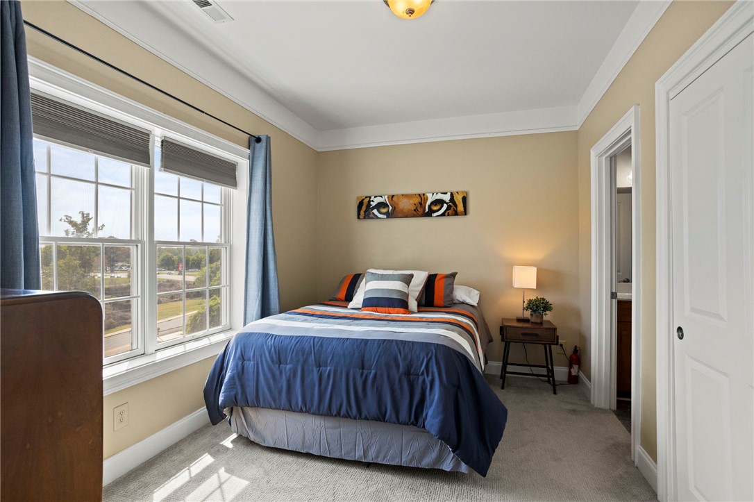 101 Oak Street, Unit 401 Clemson, SC 29631 - Photo 12 of 26 This cozy bedroom features bright windows, soft carpeting, and crown molding for a welcoming atmosphere.