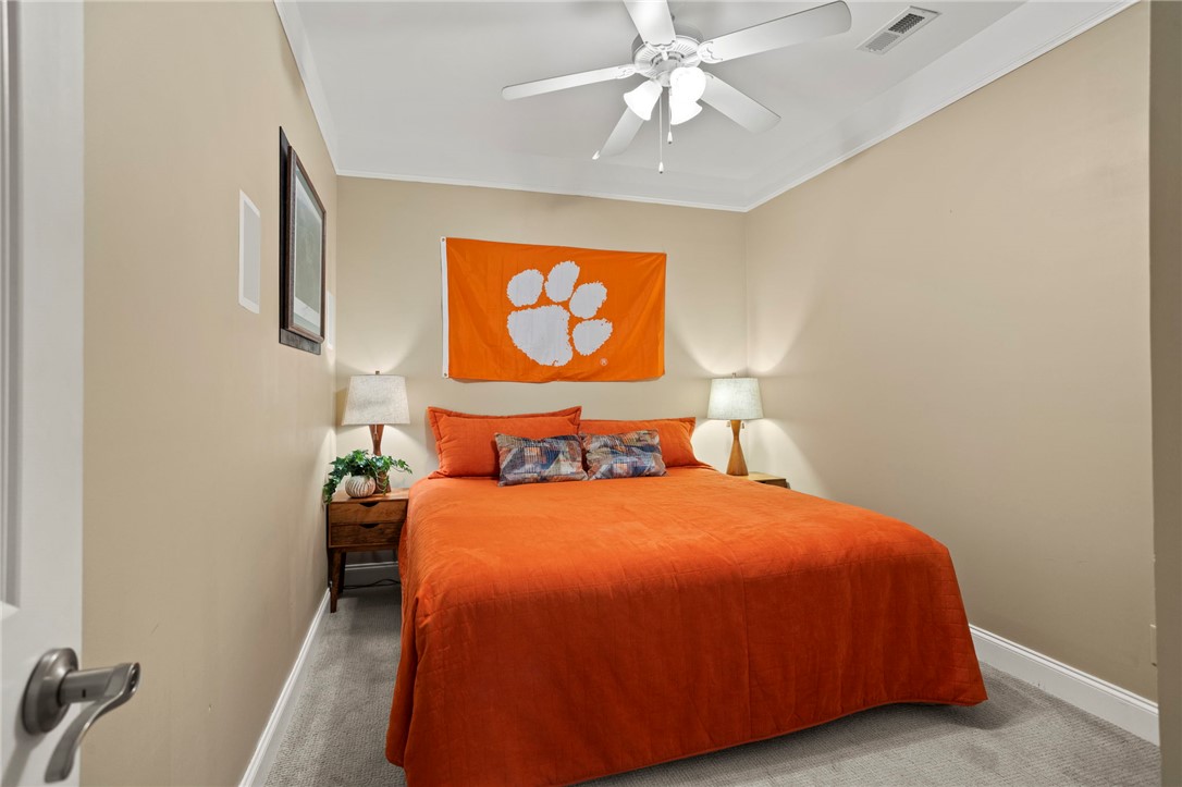 101 Oak Street, Unit 401 Clemson, SC 29631 - Photo 4 of 26 This cozy bedroom features plush carpeting and a classic ceiling fan, offering comfort and style.