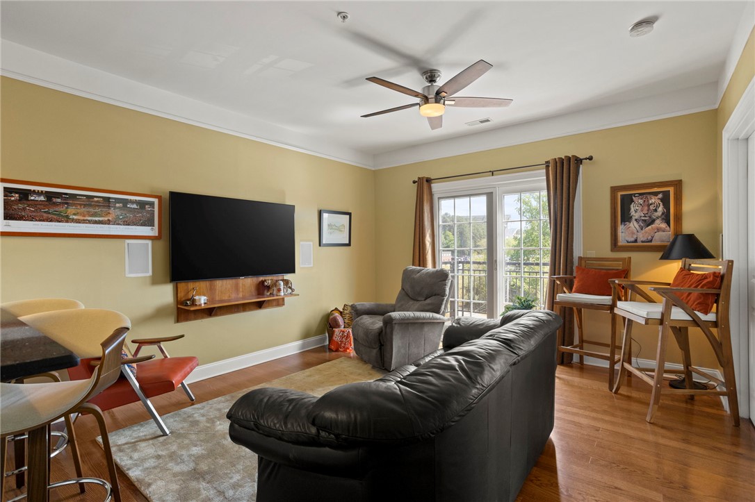 101 Oak Street, Unit 401 Clemson, SC 29631 - Photo 9 of 26 This living area features a balcony with sliding doors, crown molding, and hardwood floors.