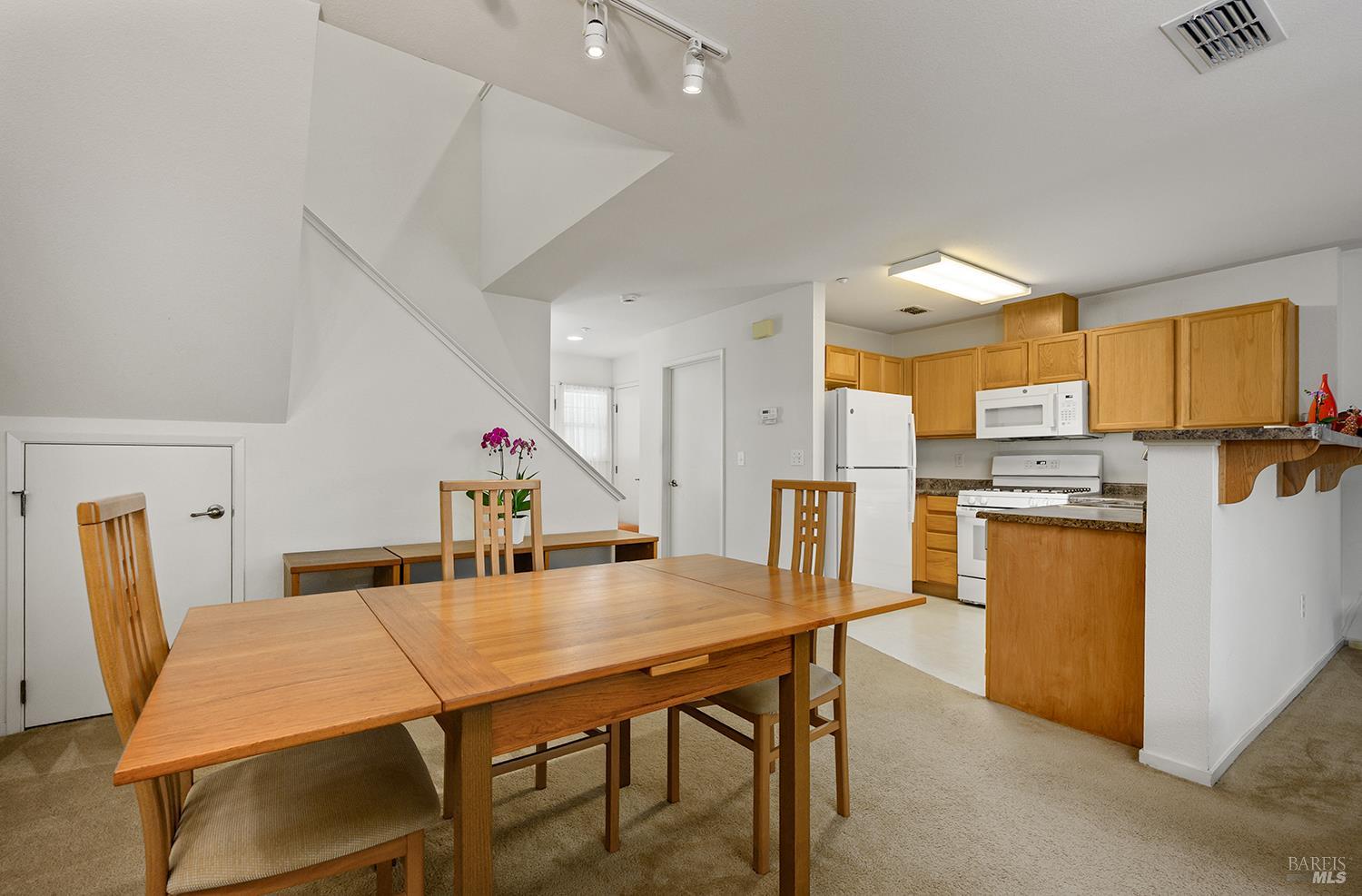 84 Crissy Place Novato, CA 94949 - Photo 12 of 37 a kitchen with stainless steel appliances refrigerator dining table and chairs