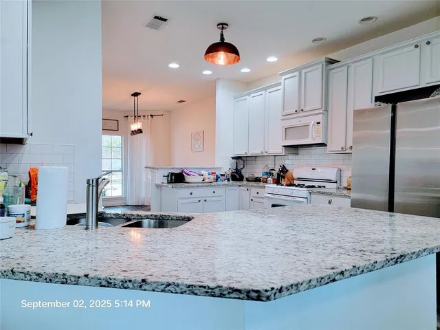 a kitchen with sink refrigerator and cabinets