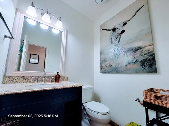 a bathroom with a sink vanity and toilet