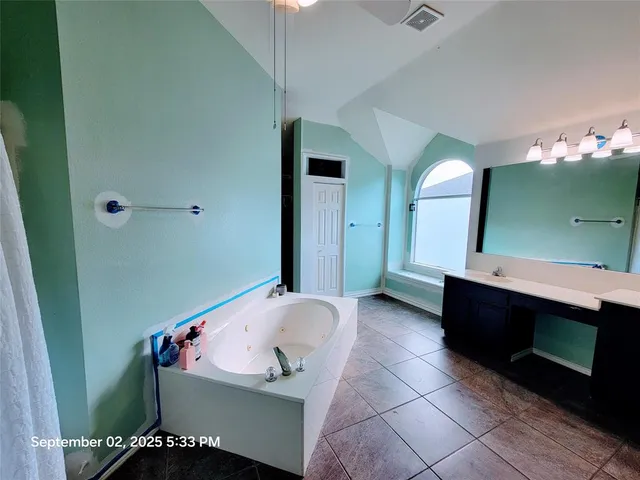 a bathroom with a bathtub sink and mirror