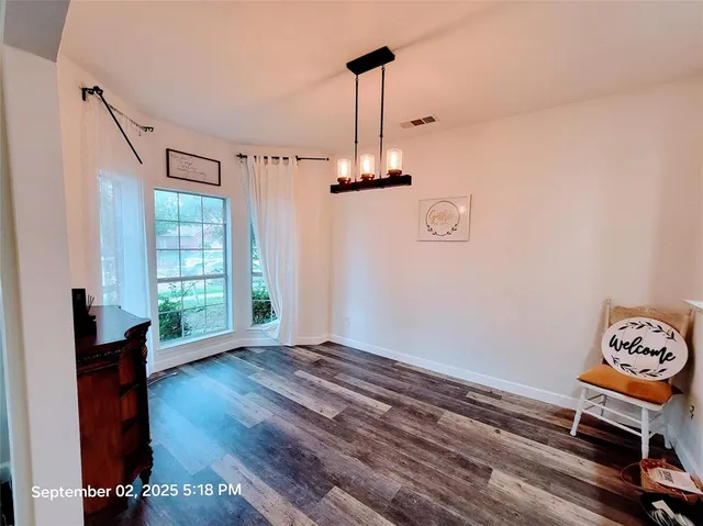 a living room with hard wood floors and a window