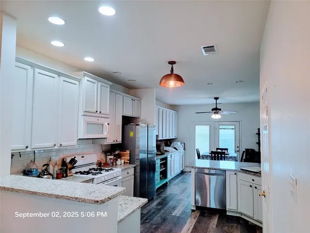 a kitchen with white cabinets and sink