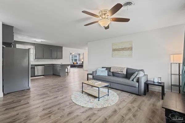 a living room with furniture and a view of kitchen