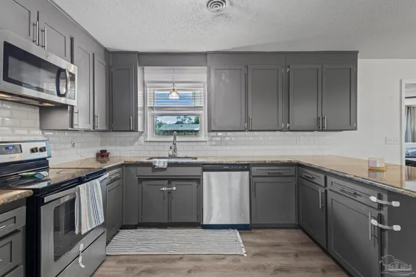 a kitchen with stainless steel appliances granite countertop a sink stove and microwave