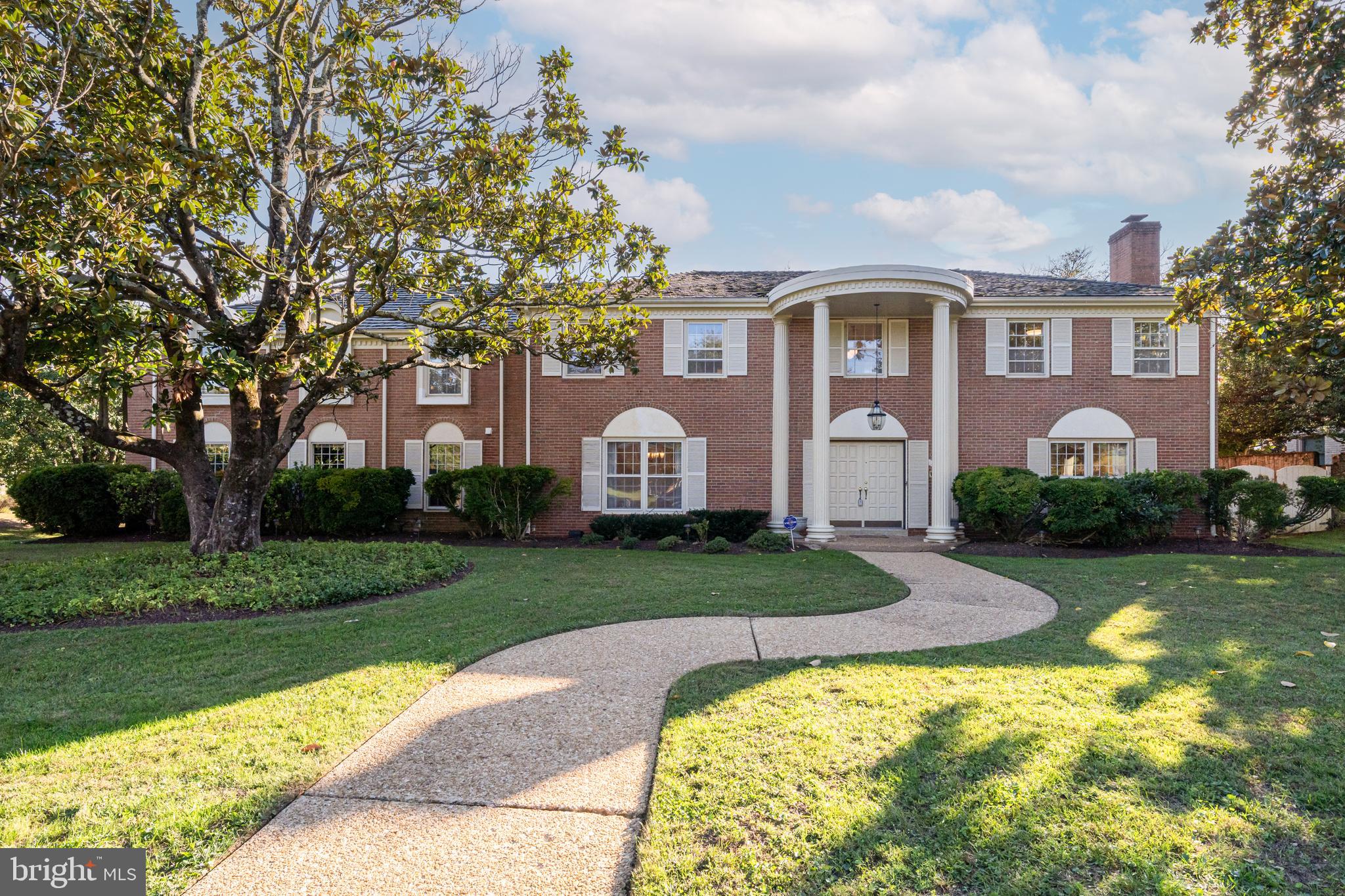 a front view of a house with a yard and trees