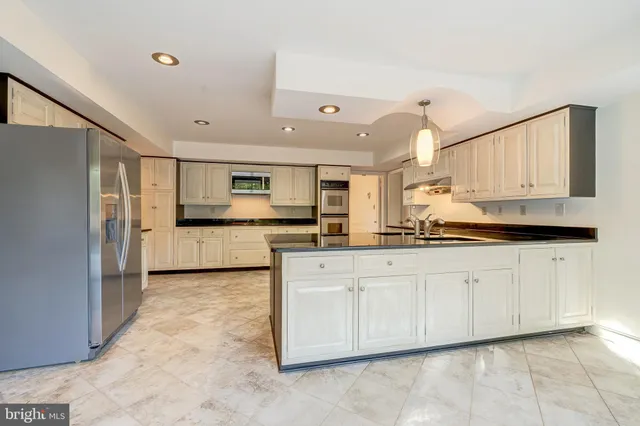 a kitchen with stainless steel appliances a refrigerator sink and cabinets
