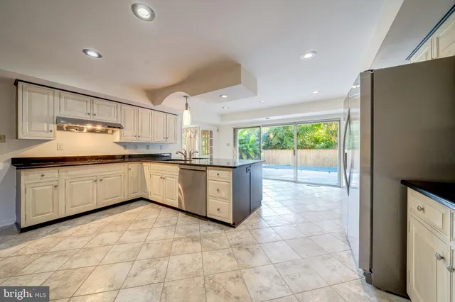 a kitchen with granite countertop white cabinets and stainless steel appliances