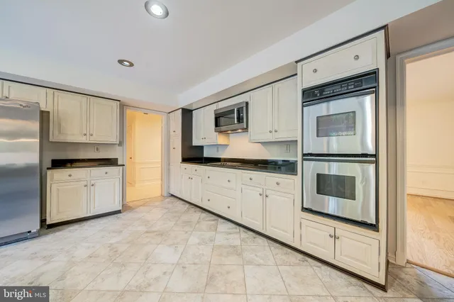 a large kitchen with cabinets and stainless steel appliances