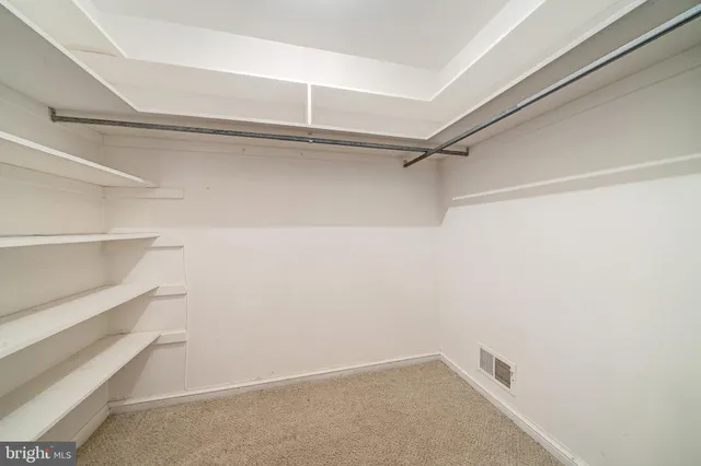 a view of a big room with windows and chandelier fan