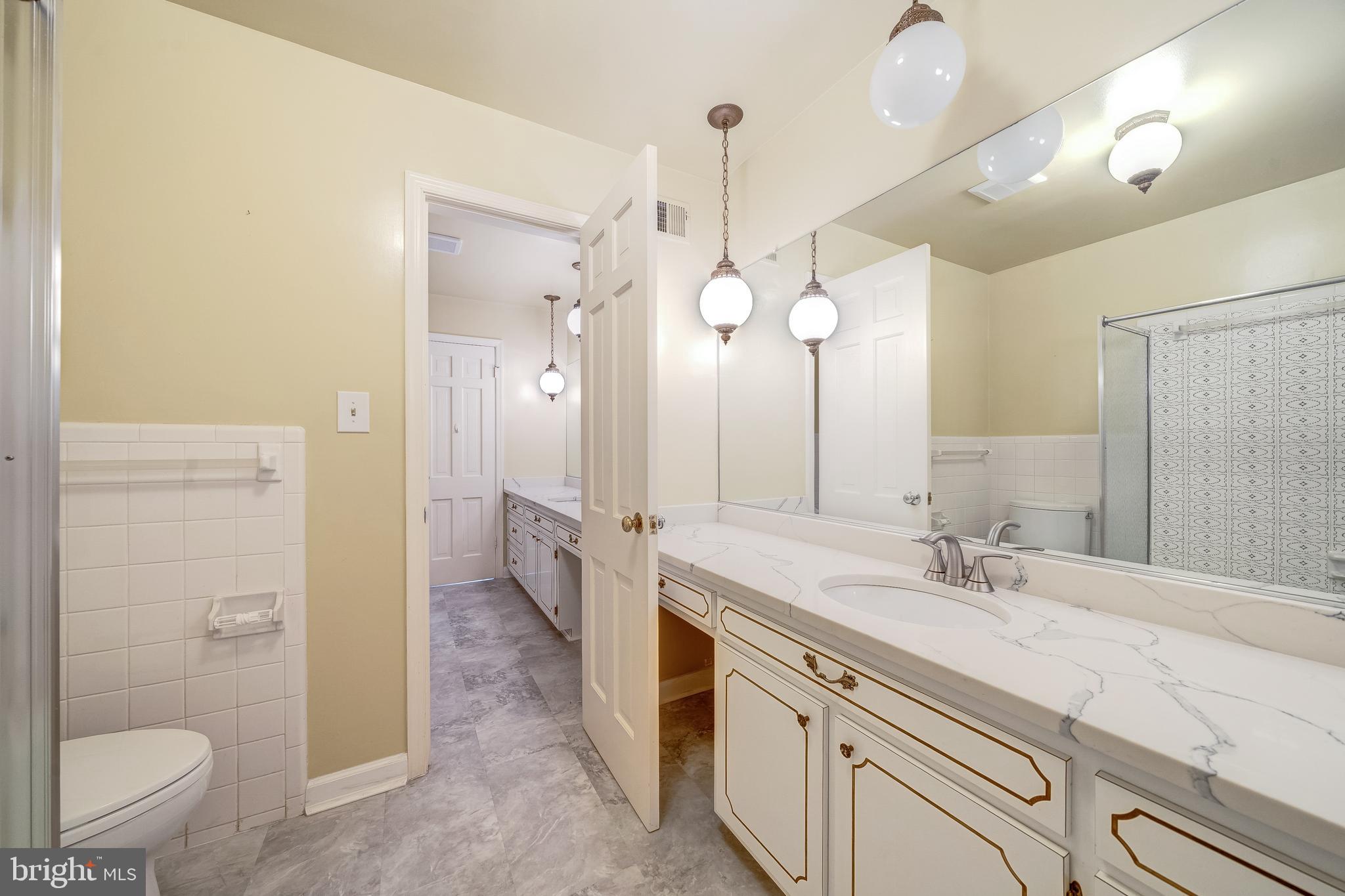 6209 Stoneham Lane McLean, VA 22101 - Photo 33 of 49 a spacious bathroom with a granite countertop sink a toilet a mirror and shower