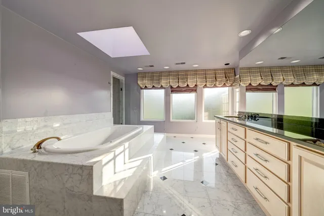 a bathroom with a bathtub shower sink and mirror